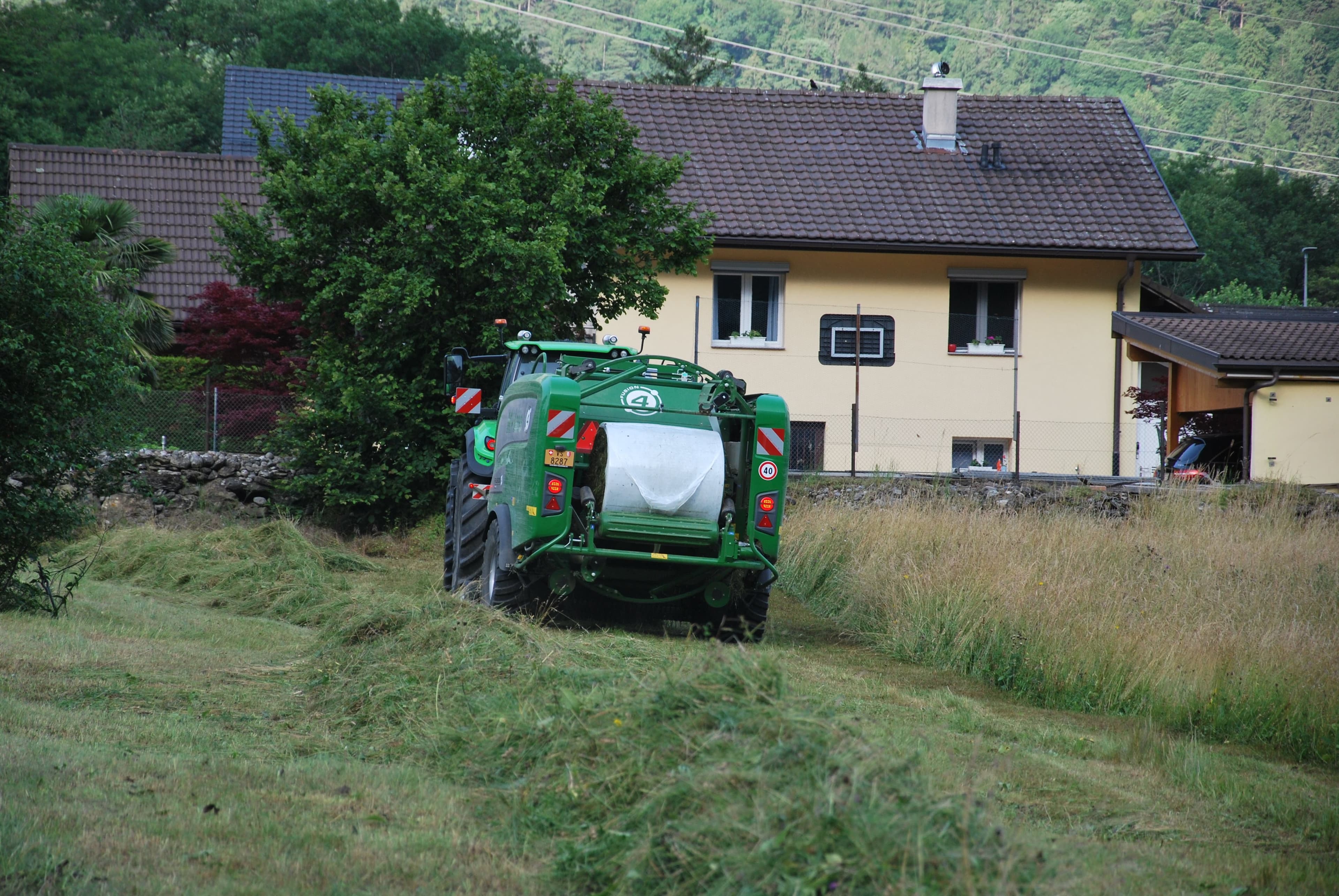 Eine Landwirtschaftsmaschine fährt über das Mahtgut.
